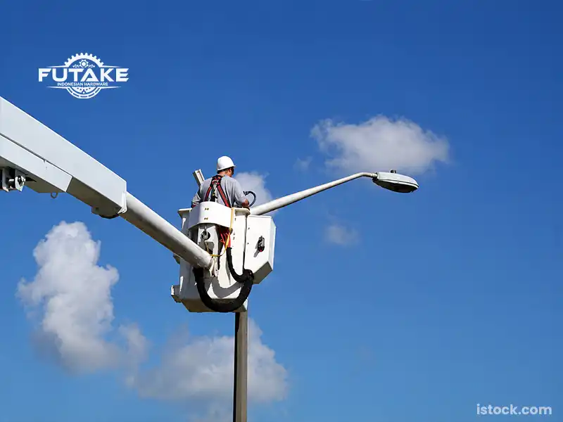 petugas yang sedang memasangan tiang lampu sesuai dengan aturan pemasangan sesuai standar tiang lampu pju