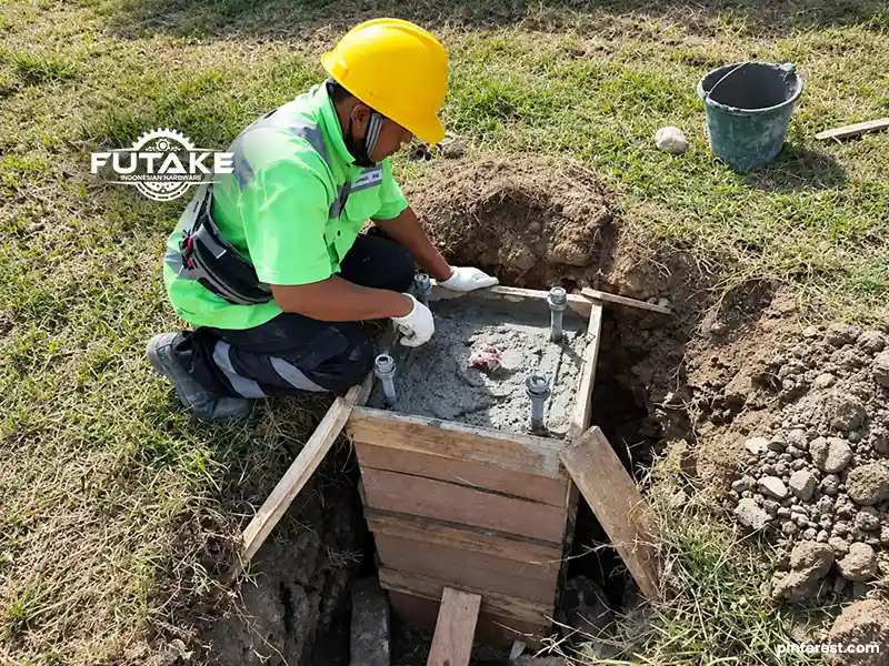orang yang sedang melakukan pengecoran pondasi tiang lampu dan meratakan permukaanya